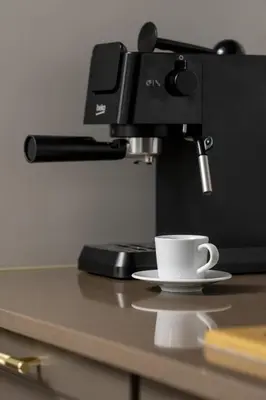 a coffee cup on a counter with a coffee machine at Atmospheric Apartment with Ideal Location in Cracow by Noclegi Renters in Kraków