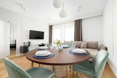 a living room with a wooden table and chairs at Atmospheric Apartment with Ideal Location in Cracow by Noclegi Renters in Kraków