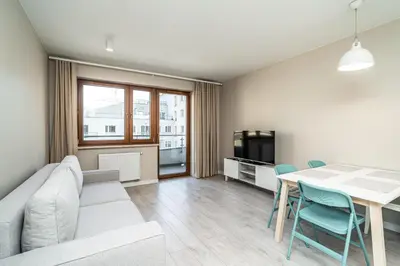 a living room with a couch and a table with chairs at RentPlanet - Apartament Rydlówka in Kraków