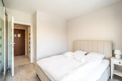 a bedroom with a large white bed with white pillows at RentPlanet - Apartament Rydlówka in Kraków