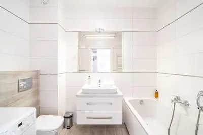 a white bathroom with a sink and a tub and a toilet at RentPlanet - Apartament Rydlówka in Kraków
