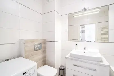a white bathroom with a sink and a toilet at RentPlanet - Apartament Rydlówka in Kraków