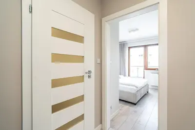 a bedroom with a sliding door with yellow and white stripes at RentPlanet - Apartament Rydlówka in Kraków