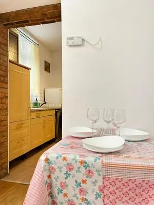 a table with two white plates and wine glasses on it at Apartment for 4 guests in historic Cracow Podgórze in Kraków