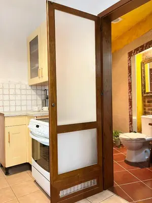 a sliding glass door in a kitchen with a toilet at Apartment for 4 guests in historic Cracow Podgórze in Kraków