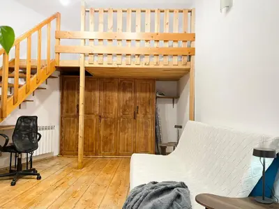 a white room with a bed with pillows and a plant at Apartment for 4 guests in historic Cracow Podgórze in Kraków