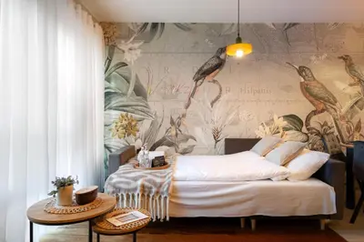 a bedroom with a bed and a mural of birds at Malila Premium Apartments Cracow Pułaskiego 14 in Kraków