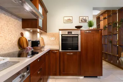 a kitchen with wooden cabinets and a microwave at Malila Premium Apartments Cracow Pułaskiego 14 in Kraków