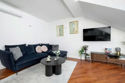 a living room with a blue couch and a table at Family Two-Level Apartment with Air Conditioning by Noclegi Renters in Kraków