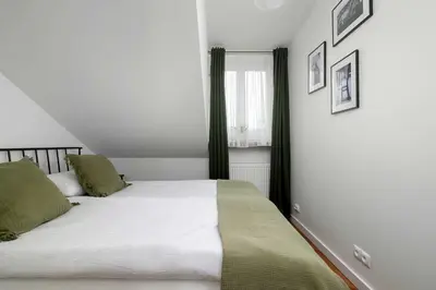a bedroom with a bed with white sheets and green pillows at Family Two-Level Apartment with Air Conditioning by Noclegi Renters in Kraków