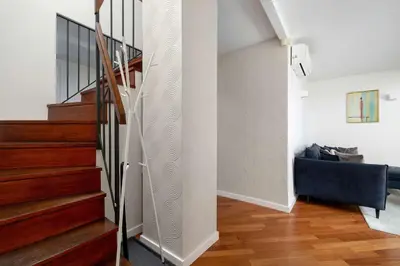 a staircase in a living room with a blue couch at Family Two-Level Apartment with Air Conditioning by Noclegi Renters in Kraków