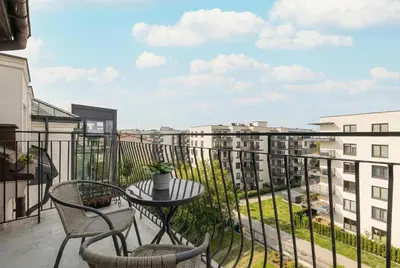 a balcony with a table and chairs and buildings at Family Two-Level Apartment with Air Conditioning by Noclegi Renters in Kraków