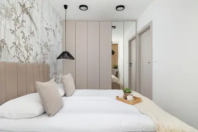 a bedroom with two white beds and a mirror at Stylowy Apartament z Parkingiem & Balkonem, Blisko Wisły by Noclegi Renters in Kraków