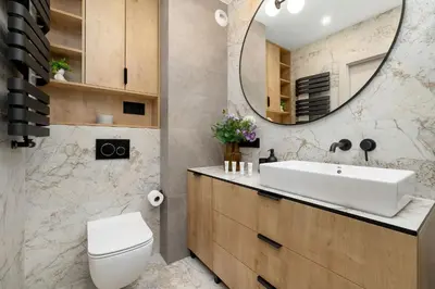a bathroom with a sink and a toilet and a mirror at Stylowy Apartament z Parkingiem & Balkonem, Blisko Wisły by Noclegi Renters in Kraków