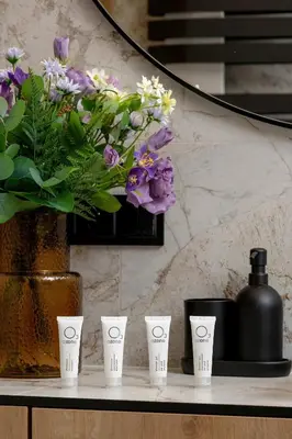 a table with four cups and a vase with flowers at Stylowy Apartament z Parkingiem & Balkonem, Blisko Wisły by Noclegi Renters in Kraków