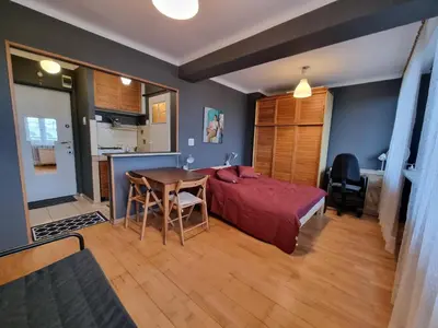 a bedroom with a bed and a table and a kitchen at mieszkanie z widokiem na Wawel in Kraków