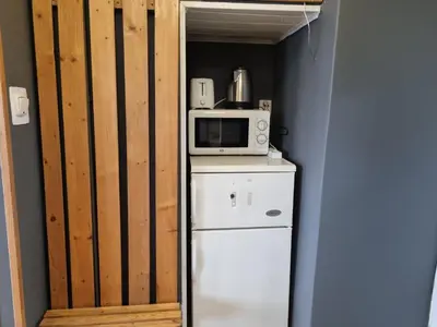 a small kitchen with a microwave on top of a refrigerator at mieszkanie z widokiem na Wawel in Kraków