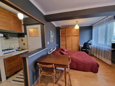 a bedroom with a bed and a table and a kitchen at mieszkanie z widokiem na Wawel in Kraków