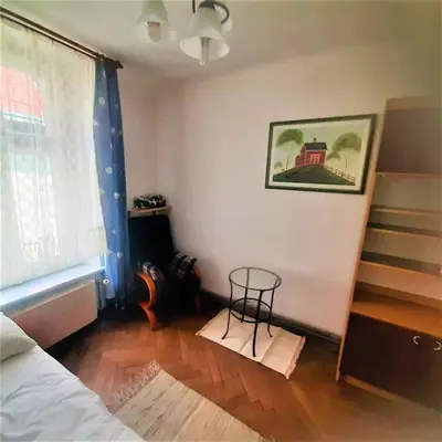 a room with a bed and a table next to a window at Let's go back to the memories in Kraków