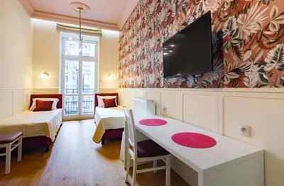 a room with two beds and a flat screen tv at Dodo Acomodo 10 - Kazimierz, Vintage - High Ceilings - Near Station in Kraków