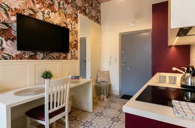 a kitchen with a desk and a television on a wall at Dodo Acomodo 10 - Kazimierz, Vintage - High Ceilings - Near Station in Kraków