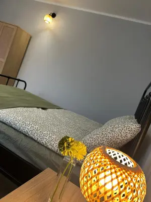 a bedroom with two beds and a lamp on a table at Apartament Paoli 2 in Zator