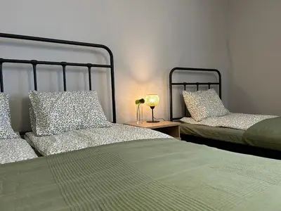 a bedroom with two beds and a table with a lamp at Apartament Paoli 2 in Zator