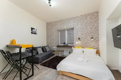 a bedroom with a bed and a brick wall at Cracow Downtown Comfort Studio by BookingHost in Kraków