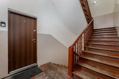 a stairway with a wooden door and a wooden staircase at Cracow Downtown Comfort Studio by BookingHost in Kraków