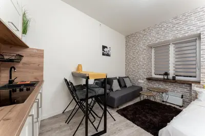 a living room with a couch and a table at Cracow Downtown Comfort Studio by BookingHost in Kraków