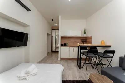 a bedroom with a bed and a table and chairs at Cracow Downtown Comfort Studio by BookingHost in Kraków