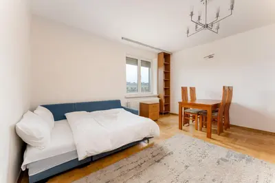 a bedroom with a bed and a dining room with a table at Nowa Huta Standard Apartment by BookingHost in Kraków
