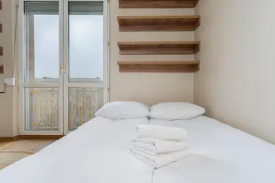 a bedroom with a white bed with towels on it at Nowa Huta Standard Apartment by BookingHost in Kraków