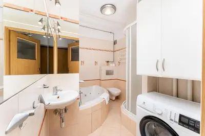 a bathroom with a sink and a washing machine at Nowa Huta Standard Apartment by BookingHost in Kraków