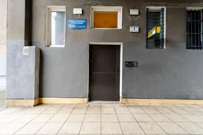 a gray building with a door and a window at Nowa Huta Standard Apartment by BookingHost in Kraków