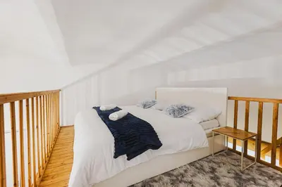 a bedroom with a large bed with white sheets and pillows at Ultracentral Downtown Sky in Kraków