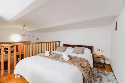 a bedroom with a bed with white sheets and pillows at Ultracentral Downtown Sky in Kraków
