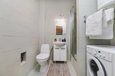 a white bathroom with a toilet and a sink at Ultracentral Downtown Sky in Kraków
