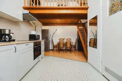 a kitchen with white cabinets and a wooden staircase at Ultracentral Downtown Sky in Kraków