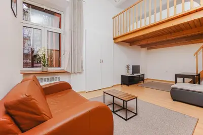 a living room with a brown couch and a table at Ultracentral Downtown Sky in Kraków
