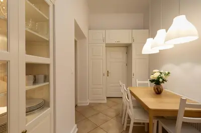 a white bedroom with a bed and a mirror at Old Town św Jana by Downtown Apartments in Kraków