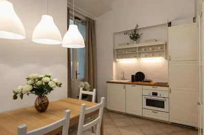 a room with a clock on the wall and a hallway at Old Town św Jana by Downtown Apartments in Kraków