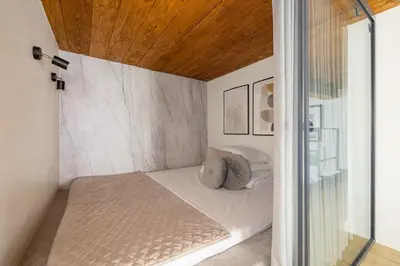 a small bed in a room with a wooden ceiling at 2 bedroom apartment - Grodzka Street - City Center in Kraków