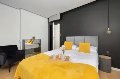 a bedroom with a large bed with yellow pillows at Tasteful Apartment in Cracow with Parking & Balcony by Nolcegi Renters in Kraków