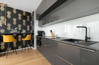 a kitchen with a sink and some yellow stools at Tasteful Apartment in Cracow with Parking & Balcony by Nolcegi Renters in Kraków