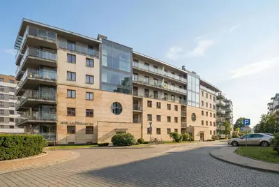 an apartment building on a street with a car parked in front at Tasteful Apartment in Cracow with Parking & Balcony by Nolcegi Renters in Kraków