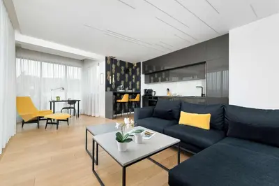 a living room with a blue couch and a table at Tasteful Apartment in Cracow with Parking & Balcony by Nolcegi Renters in Kraków