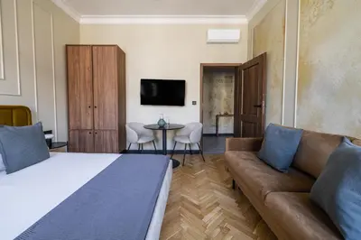 a bedroom with a bed and a couch and a table at 3 bedroom - Grodzka Street - Old Town in Kraków