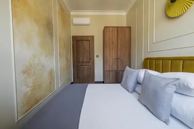 a bedroom with a white bed and two wooden doors at 3 bedroom - Grodzka Street - Old Town in Kraków