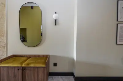 a mirror and a wooden bench in a room at 3 bedroom - Grodzka Street - Old Town in Kraków
